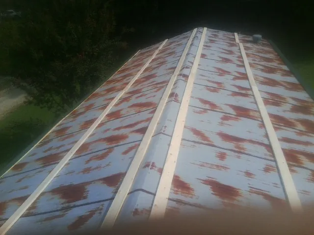 Rusted metal roof panels with new wood purlins before replacement — Storm Damage Roof Repair in Hobgood by Roofing Brothers