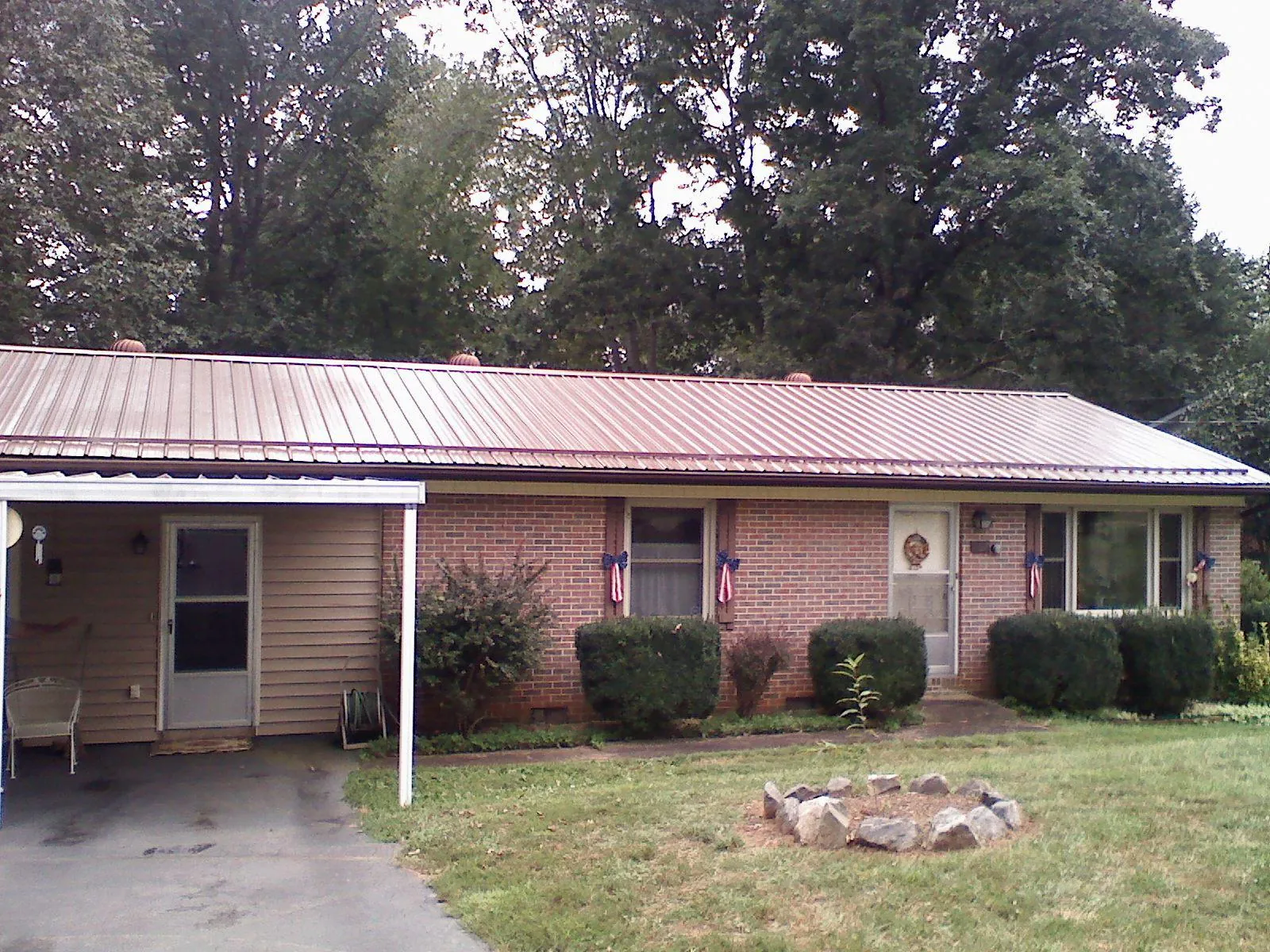 Bronze metal roof and carport on a brick ranch home — Roof Repair work by our crew in Hobgood